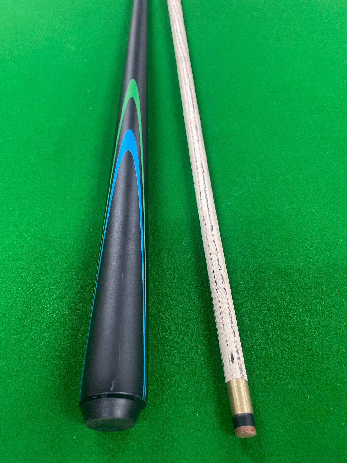 Snooker cue with black and blue design on a green felt background